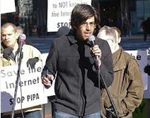 Aaron Swartz in piedi che parla al microfono durante una protesta contro il SOPA.